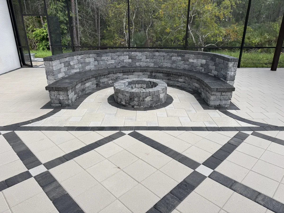 Close view of curved gray block seating around a circular masonry feature on cream paving
